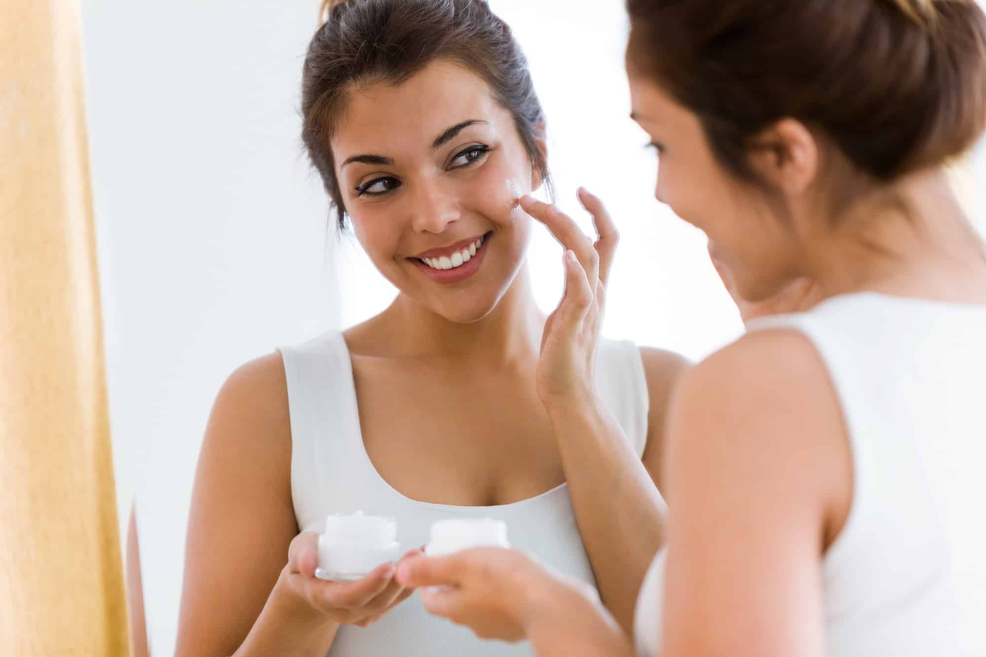 Pretty young woman caring of her skin standing near mirror | ANEU Medical Spa, LLC | Madison | McFarland, WI